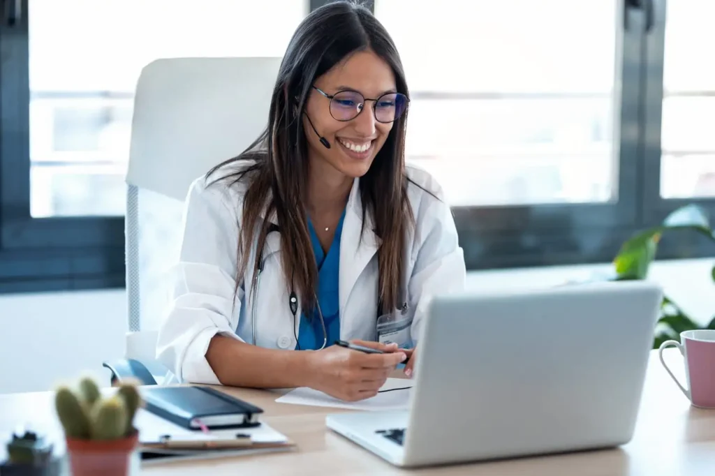 medical office receptionist on her laptop smiling